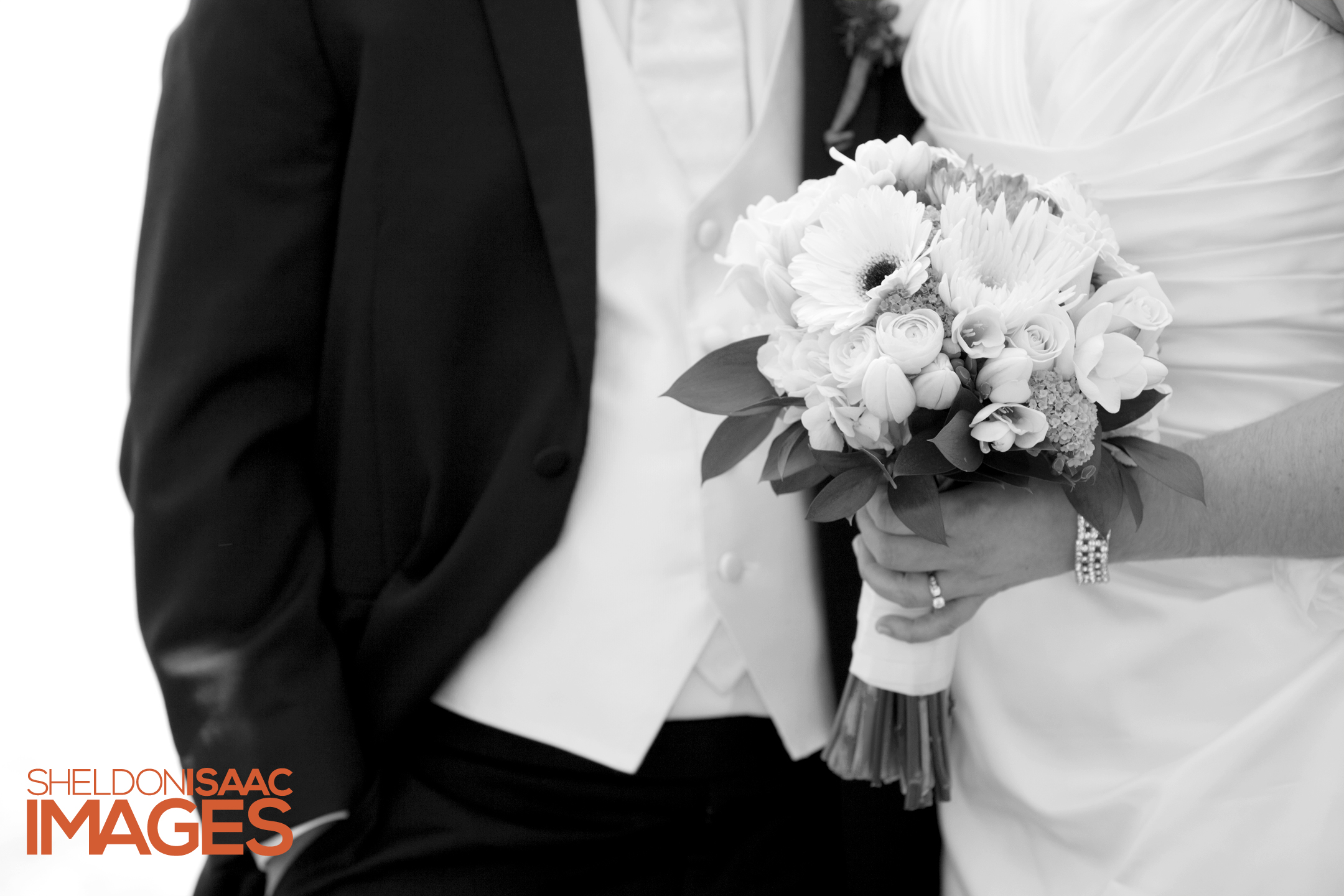 Bride is holding her bouquet standing near her groom.