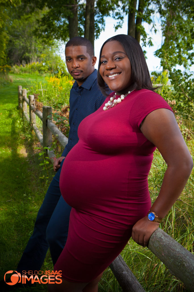 Pregnancy photo of wife and husband looking at camera