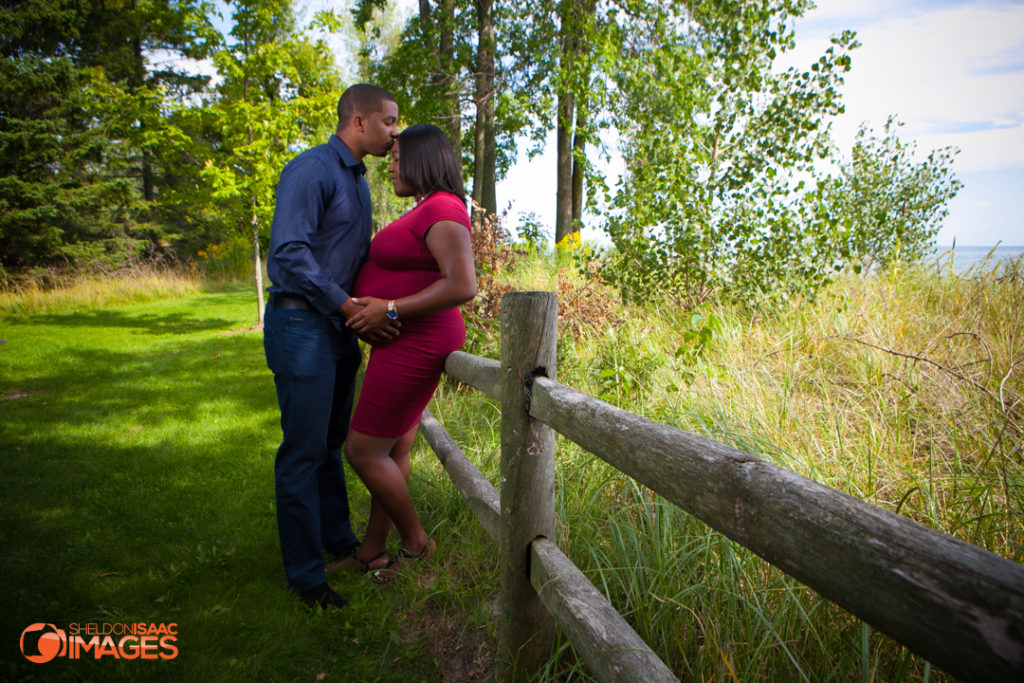 Maternity Photo husband kissing wife in a park