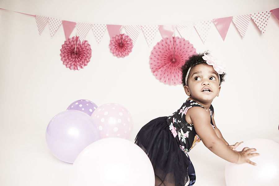 Baby smiling at the camera during a cake smash photoshoot