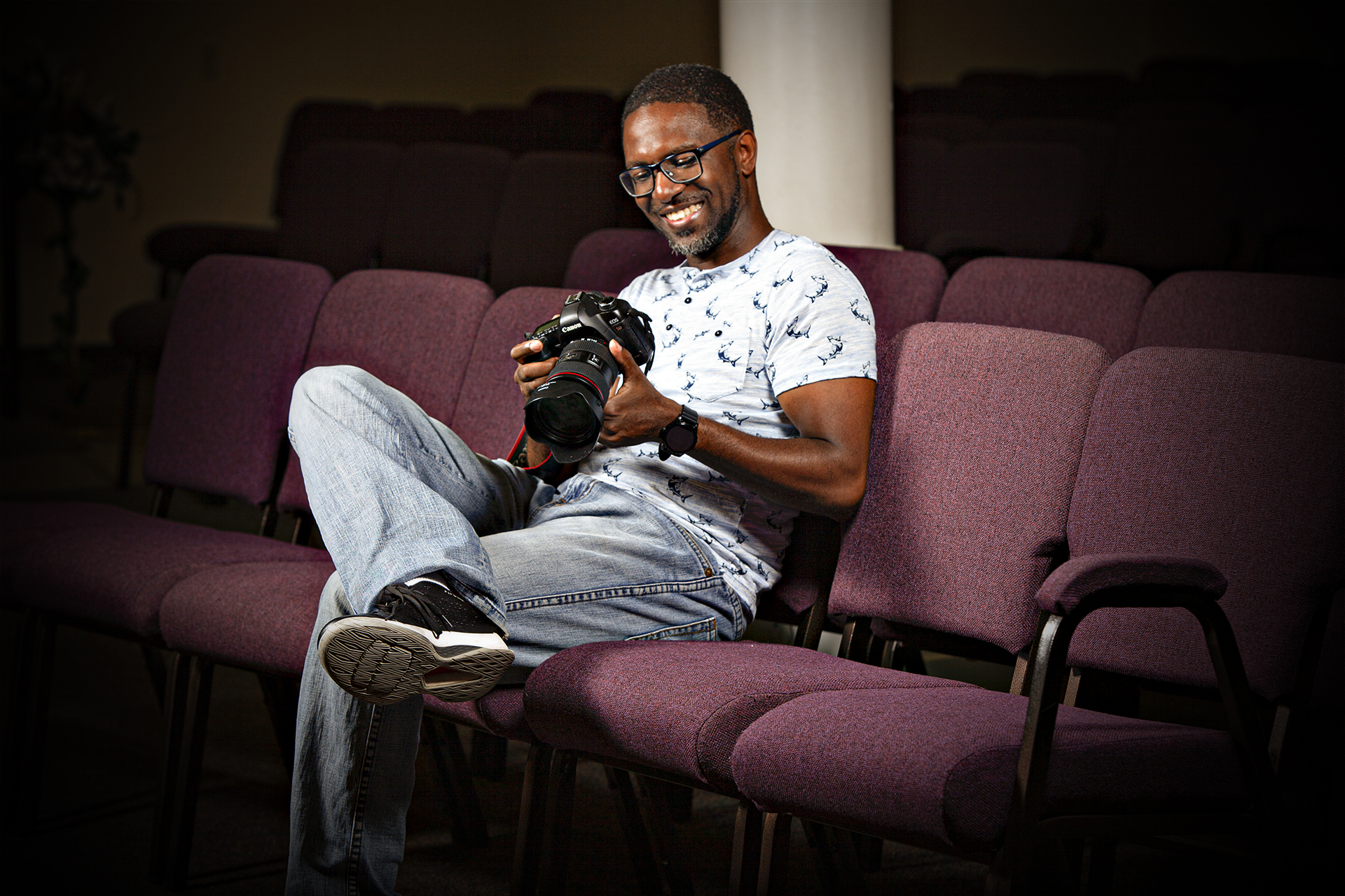 Sheldon Isaac smiling at a photo on his camera in Scarborough