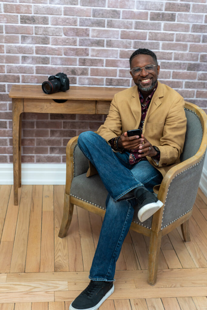 Sheldon Isaac smiling at a photo on his camera in Whitby