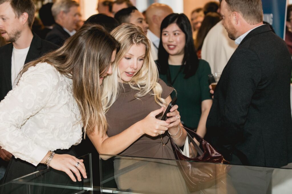 Awards night photographer Toronto - two guests viewing event photos on a phone at a reception