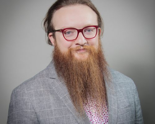 Man with a beard posing for a headshot