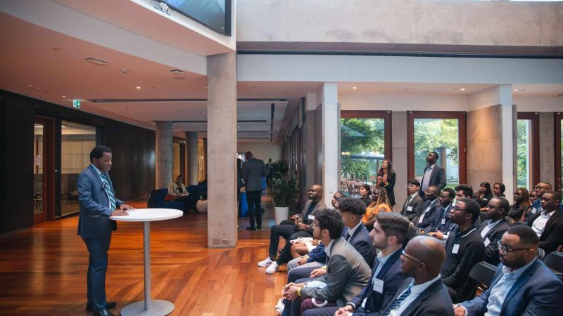Conference photographer Toronto - speaker addressing a seated business audience in a sunlit atrium venue