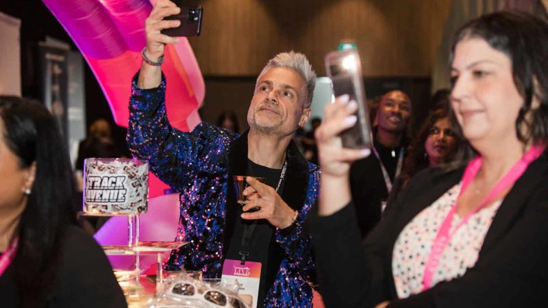 Trade show photographer Toronto - attendee in a sequined blazer taking a selfie on the EventFest show floor