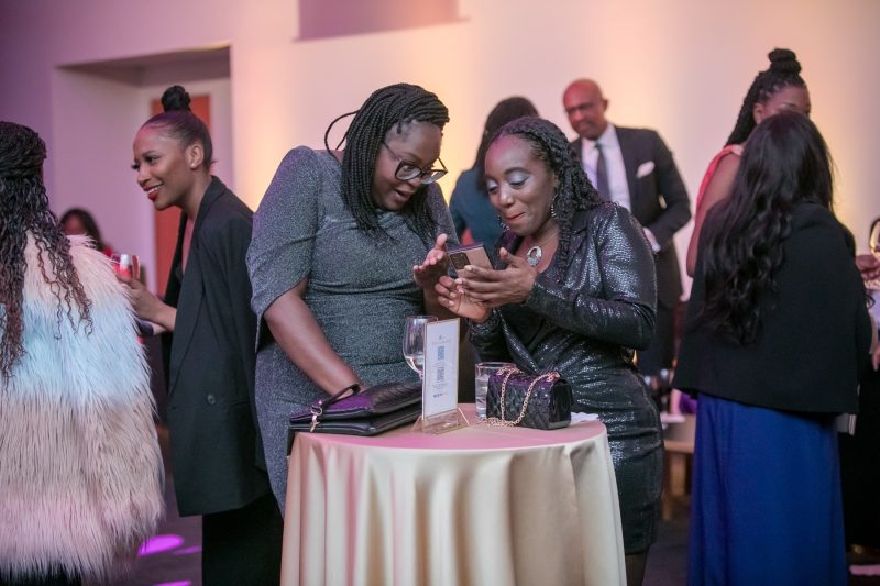 Gala photographer Toronto - guests sharing event photos at a cocktail table